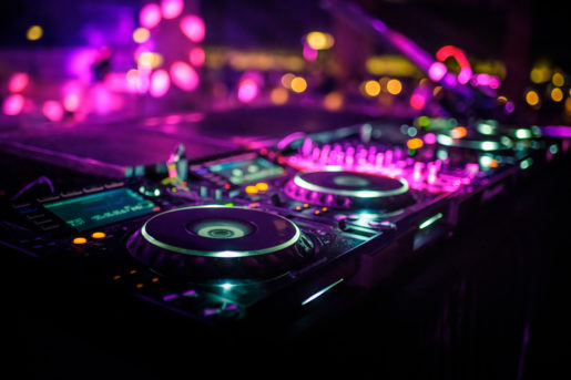 DJ console desk at party, bright pink party lights